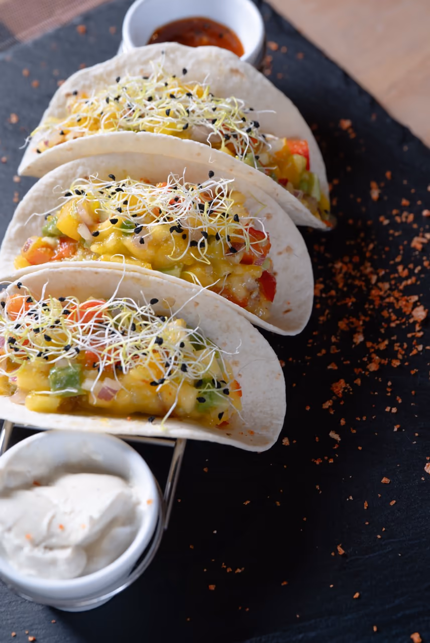 Tacos vegetales estilo Paprika sobre pizarra con pimentón